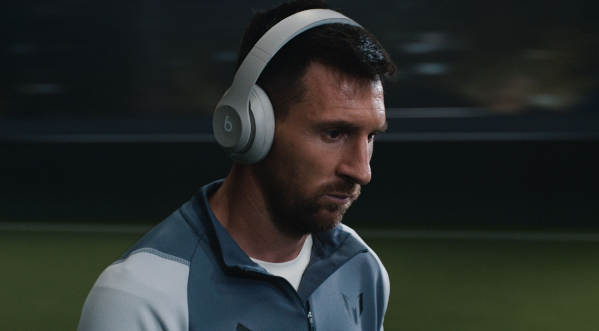 Lionel Messi standing on a field wearing Beats Studio Pro