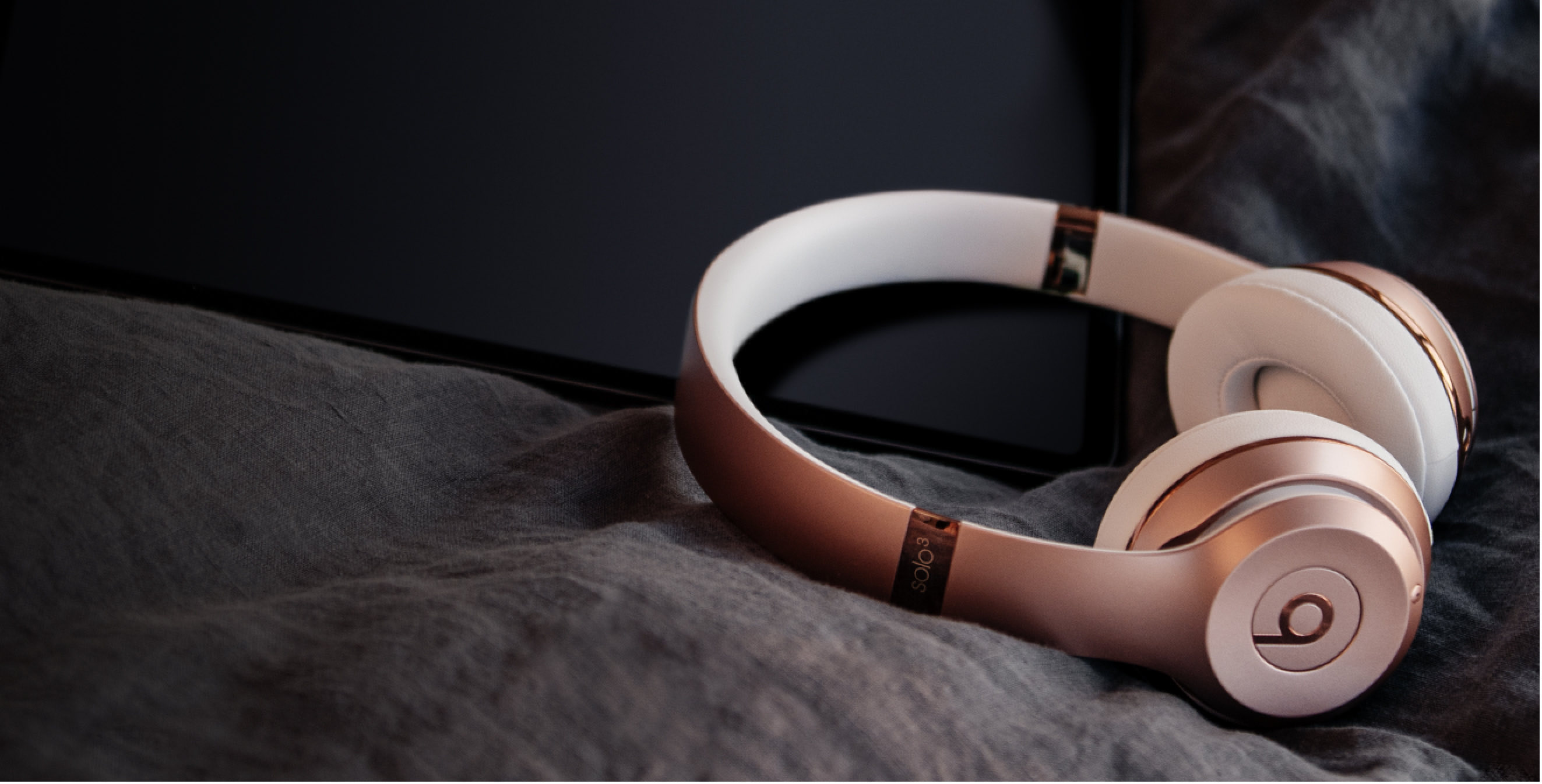 Beats Solo3 Wireless headphones in rose gold shown lying down